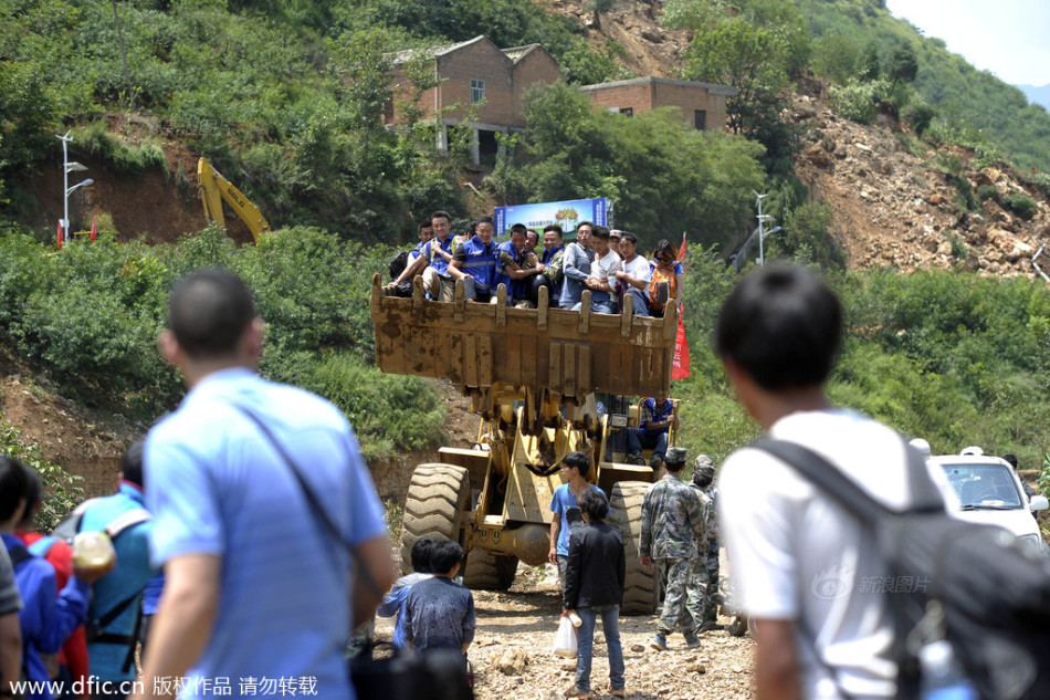 鲁甸灾民乘坐挖掘机过河
