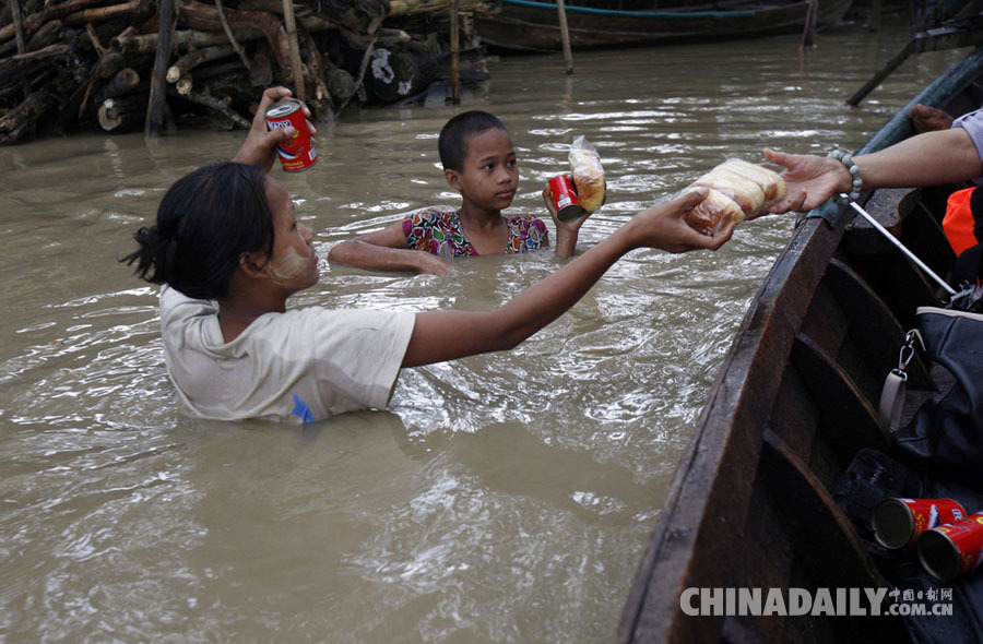 缅甸全国洪水泛滥 灾民水中领取救济食物