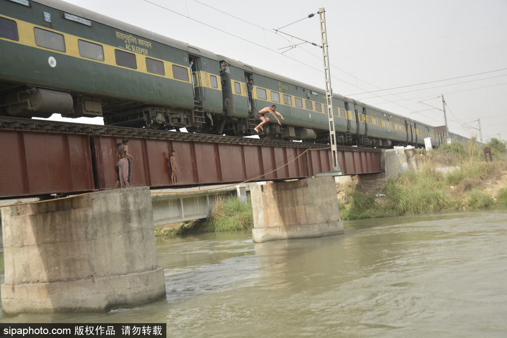 实拍印度男孩火车外玩特技 纵身跃入恒河