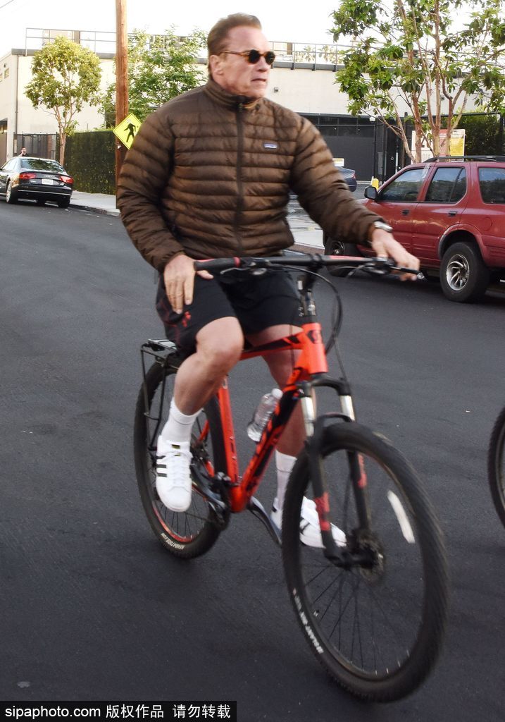 施瓦辛格穿羽绒服街头骑单车运动范十足