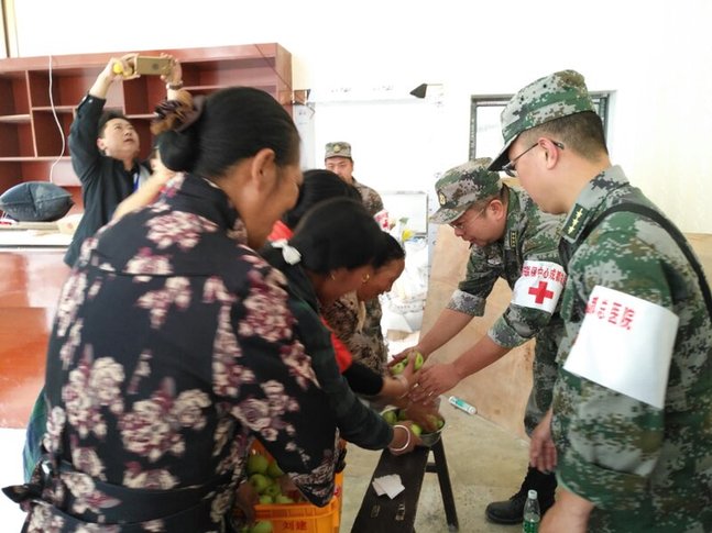 茂县灾区群众自发给参加救援的部队医疗队送水果