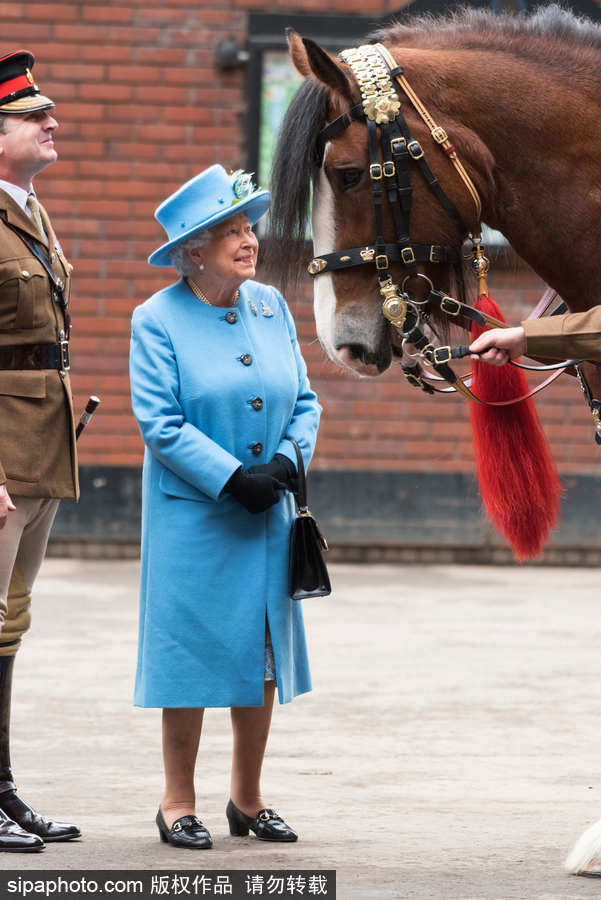 英国女王伊丽莎白二世到访骑兵队 身着天蓝色风衣面露微笑
