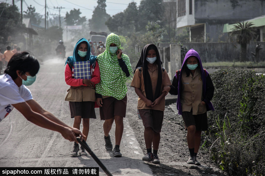 锡纳朋火山喷发后 火山灰漫山遍野村民戴口罩清扫