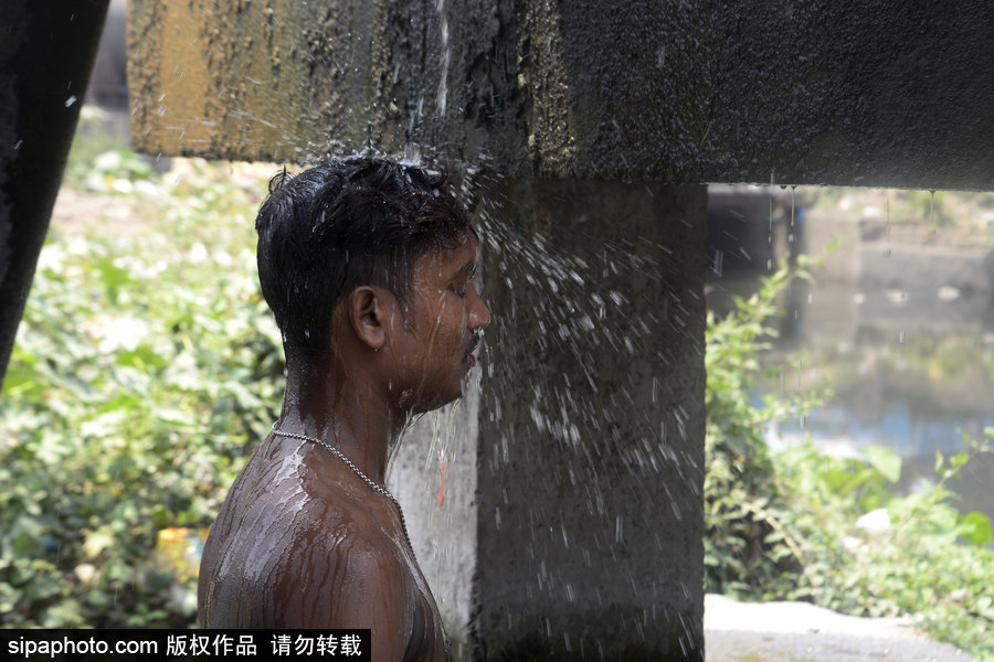 印度加尔各答高温来袭 民众室外冲凉降温