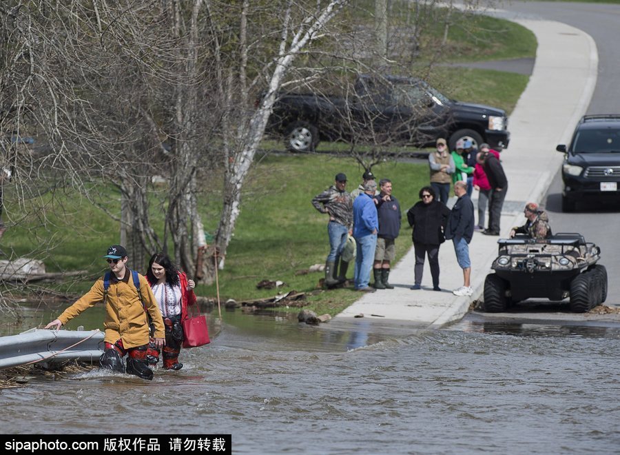 加拿大街道洪水泛滥 民众被迫淌水出行