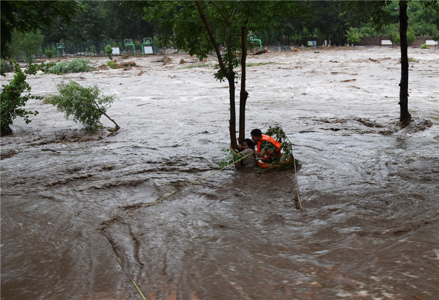 北京持续暴雨引发山洪 女子紧抱大树被消防营救