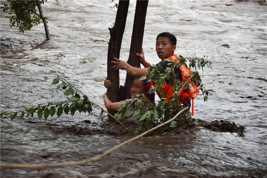 北京持续暴雨引发山洪 女子紧抱大树被消防营救