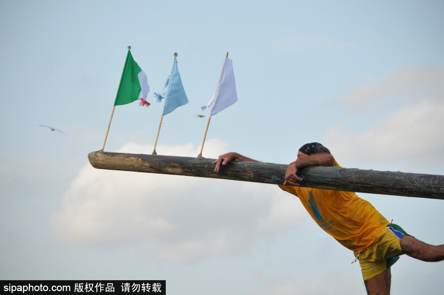 这项传统比赛刺激又好玩！意大利渔民过独木桥摘旗子五花八门落水姿势令人捧腹