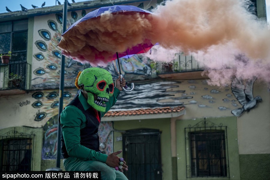 展现色彩魅力！墨西哥街头“彩色骷髅”花6小时用彩烟“填满”街道